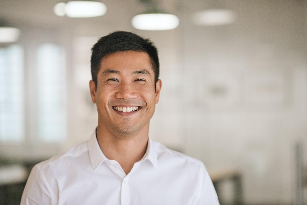 asian man in white shirt smiling | bone grafting high point nc