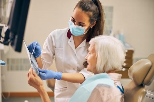 dentist with older patient looking at paperwork | dentist in high point