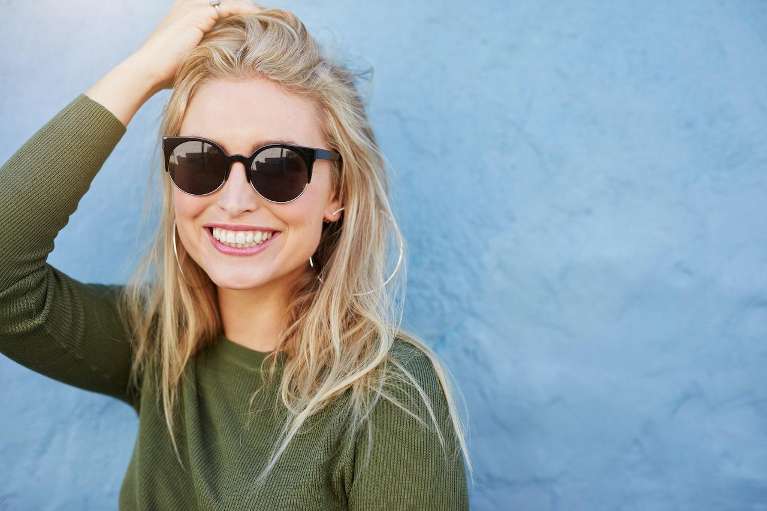 blonde woman with green sweater smiling | clear aligners high point nc