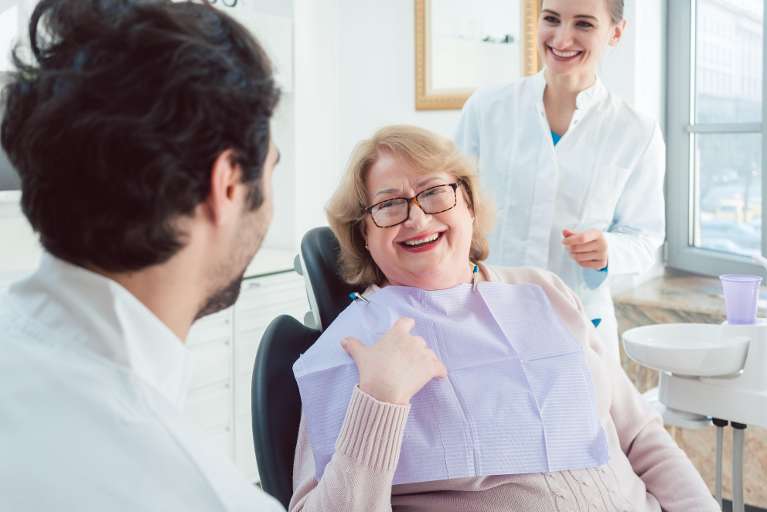 older woman sitting in dentist exam chair | high point dentist