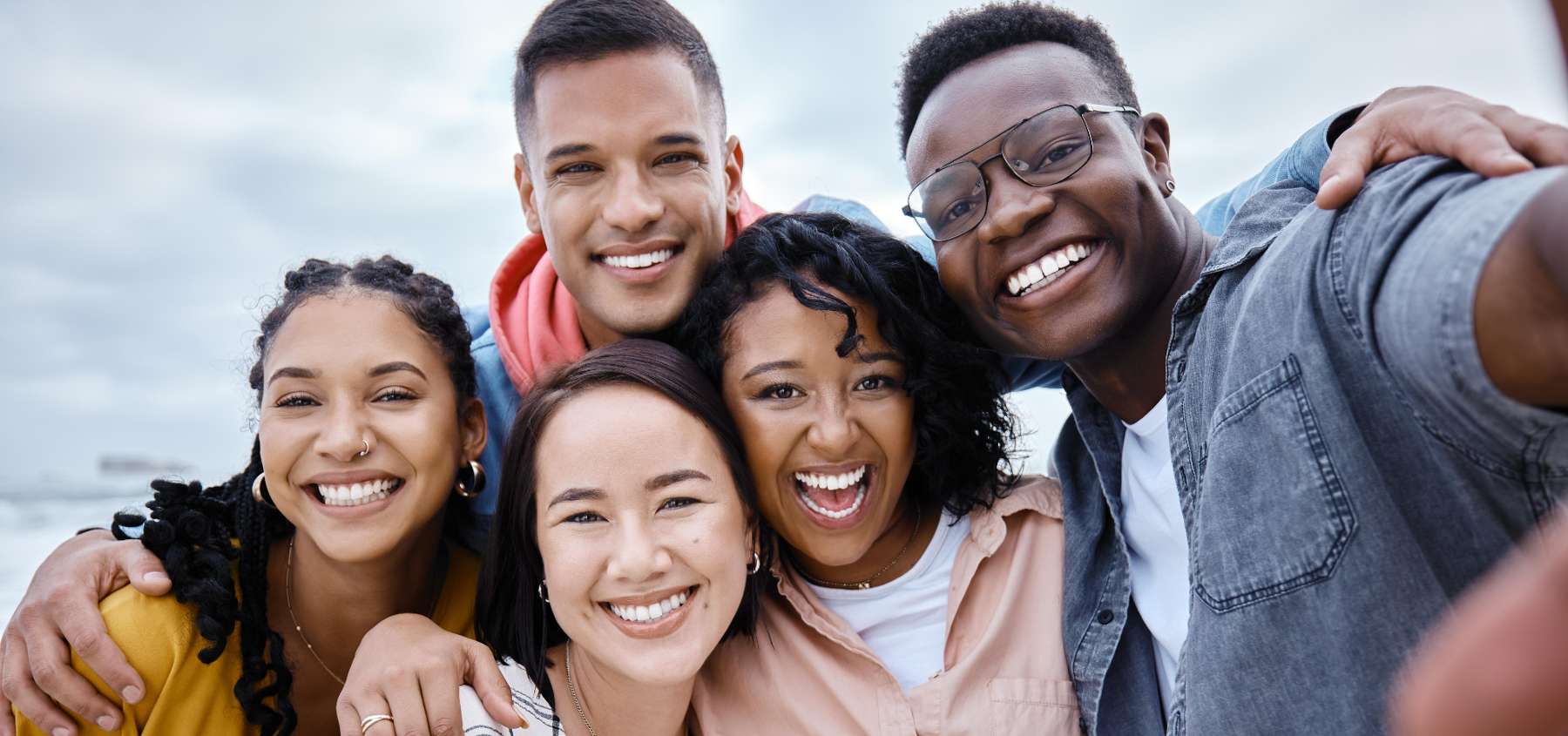 group of five friends hugging | dentist near me